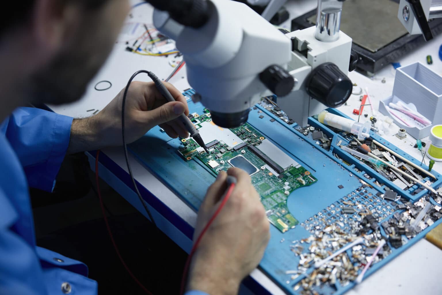 Técnico reparando placa madre de laptop en taller de Huamachuco